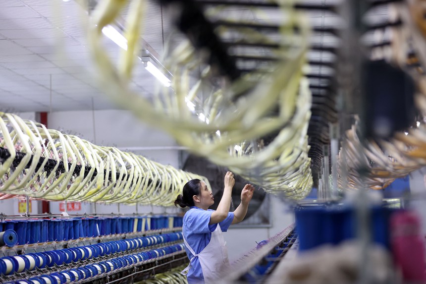絲綢紡織女工在生產車間忙碌。楊敏攝